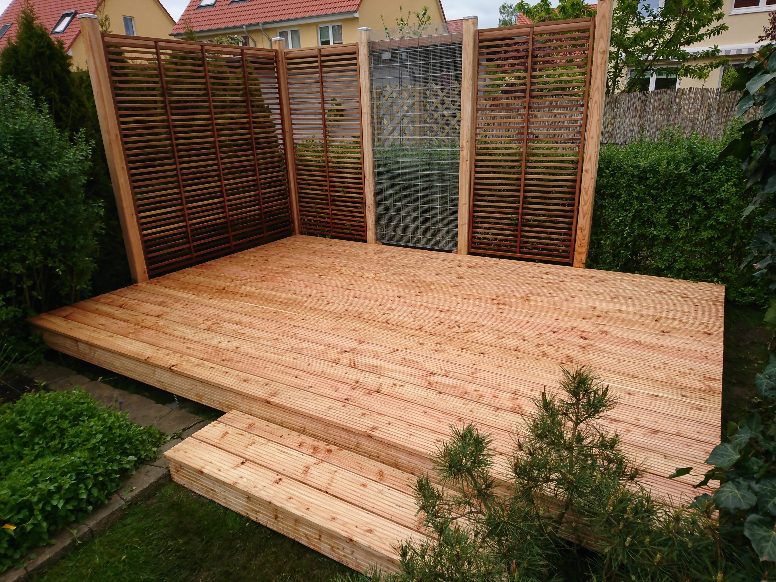 Terrasse aus Lärchenholz mit Sichtschutz und Rankhilfe von EberHolz Design